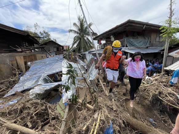 epa09653261 A handout photo made available by the Office of the Vice President of the Philippines (OVP) shows Vice-president Leni Robredo (R) inspecting a village in the typhoon devastated city of Bai ...