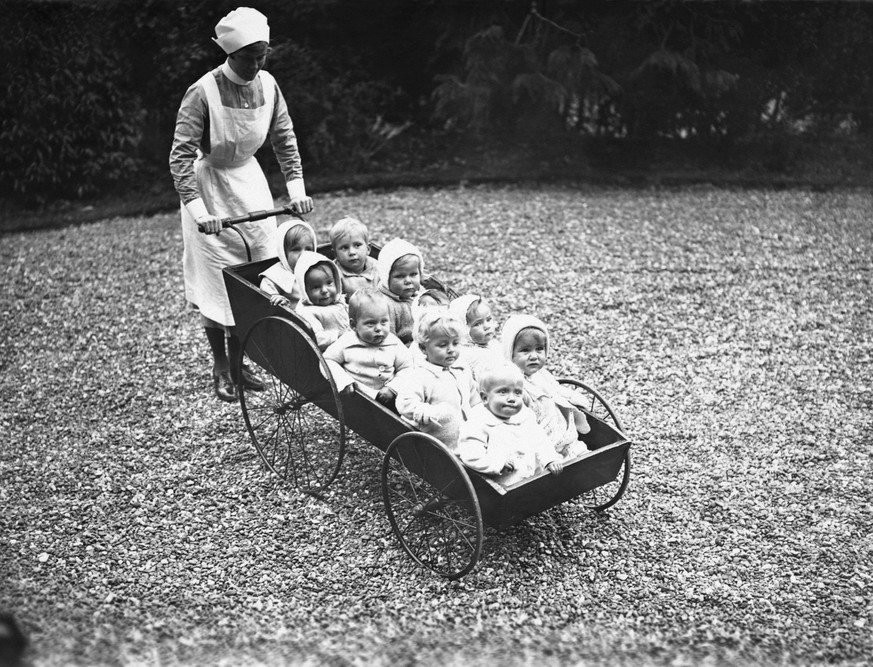 A nurse from Doctor Barnardo&#039;s Babies Castle, at Hawkhurst, prepares to take a group of babies for pram ride. | Location: Hawkhurst, Kent, England, UK. (Photo by © Hulton-Deutsch Collection/CORBI ...