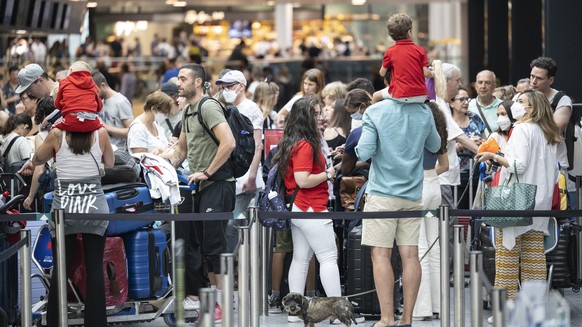 Menschen warten am Flughafen auf ihren Abflug in die Ferien, aufgenommen am Samstag, 16. Juli 2022 auf dem Flughafen in Zuerich. (KEYSTONE/Ennio Leanza)