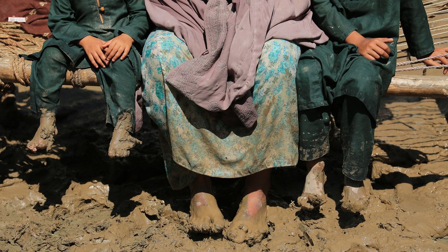 epaselect epa10143349 People sit on a bench in the aftermath of floods in Charsadda District, Khyber Pakhtunkhwa province, Pakistan, 28 August 2022. According to the National Disaster Management Autho ...