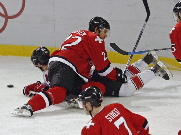 Swiss defender Olivier Keller, top, keeps down Canadian Martin St. Louis during their men's preliminary round group A ice hockey match Canada against Switzerland at Torino Esposizioni in Turin, I ...