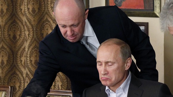 FILE - Yevgeny Prigozhin, top, serves food to then-Russian Prime Minister Vladimir Putin at Prigozhin's restaurant outside Moscow, Russia on Nov. 11, 2011. Prigozhin, the millionaire and owner of the…