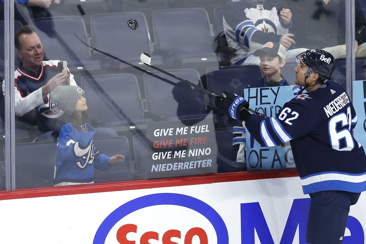 NHL, Eishockey Herren, USA New Jersey Devils at Winnipeg Jets Nov 14, 2023 Winnipeg, Manitoba, CAN Winnipeg Jets right wing Nino Niederreiter 62 tosses a puck to a fan before a game against the New Je ...