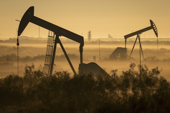 Fog blankets a low-lying area where pumpjacks operate in West Texas, northeast of Kermit, on Sept. 12, 2018. In December 2017, companies in the Permian Basin _ an ancient, oil-rich seabed that spans W ...