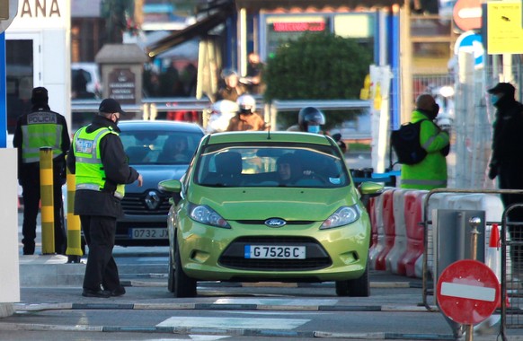 epa08909686 A Gibraltarian Police officer checks a car at the border with Spain, in Gibraltar, 29 December 2020. The Spanish Government has passed a transitory law that allows EU citizens resident in  ...