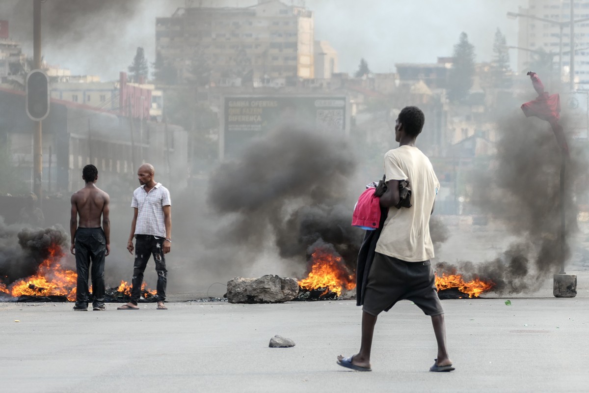 epa11791180 People stand next to a burning barricade during a protest after the Constitutional Council proclaimed Daniel Chapo as the winner of the presidential election with 65.17% of the votes, in M ...
