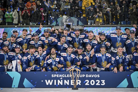 Davos' team celebrate with the trophy after winning the final game between Switzerland's HC Davos and HC Dynamo Pardubice, at the 95th Spengler Cup ice hockey tournament in Davos, Switzerlan ...