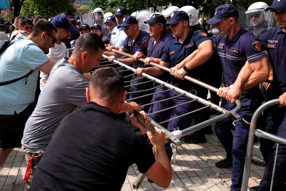 Protesters try to remove a barricade as police hold it during clashes at an anti-government rally in Tirana, Albania, Thursday, July 2, 2026. (AP Photo/Hameraldi Agolli)
APTOPIX Albania Protest