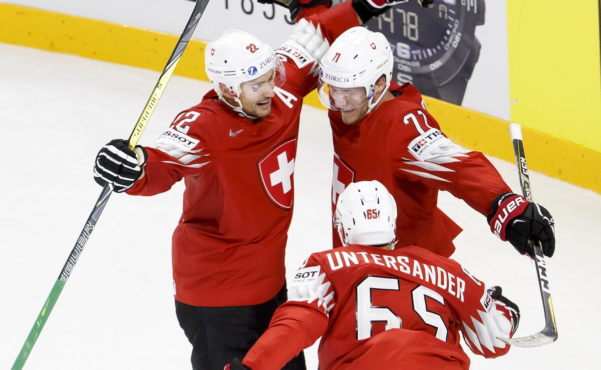 Switzerland's forward Enzo Corvi #71, celebrates his goal with teammate forward Nino Niederreiter #22, and defender Ramon Untersander #65, after scoring the winner goal, during the overtime of th ...