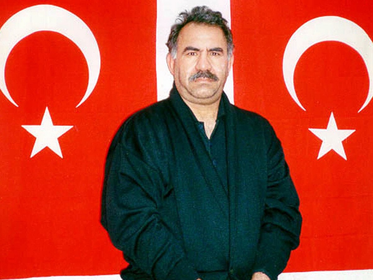 Kurdish rebel leader Abdullah Ocalan poses in front of Turkish flags before being interrogated by Turkish officials at the prison-island of Imrali in this image provided by the Turkish Intelligence Se ...