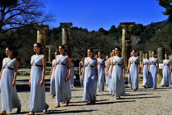 epa08289143 Greek actresses in the role of priestesses perform during the Lighting Ceremony? of the Olympic Flame for the Tokyo Summer Olympics, in front of Hera Temple in Ancient Olympia, Greece, on  ...