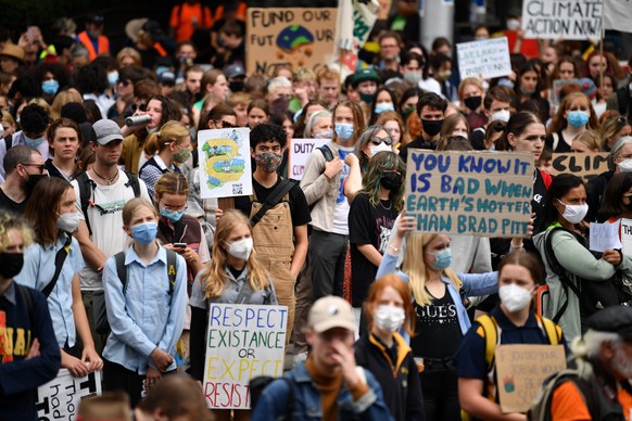 epa09848101 School students hold placards during a Climate School Strike protest at Treasury Gardens in Melbourne, Australia, 25 March 2022. EPA/JOEL CARRETT AUSTRALIA AND NEW ZEALAND OUT