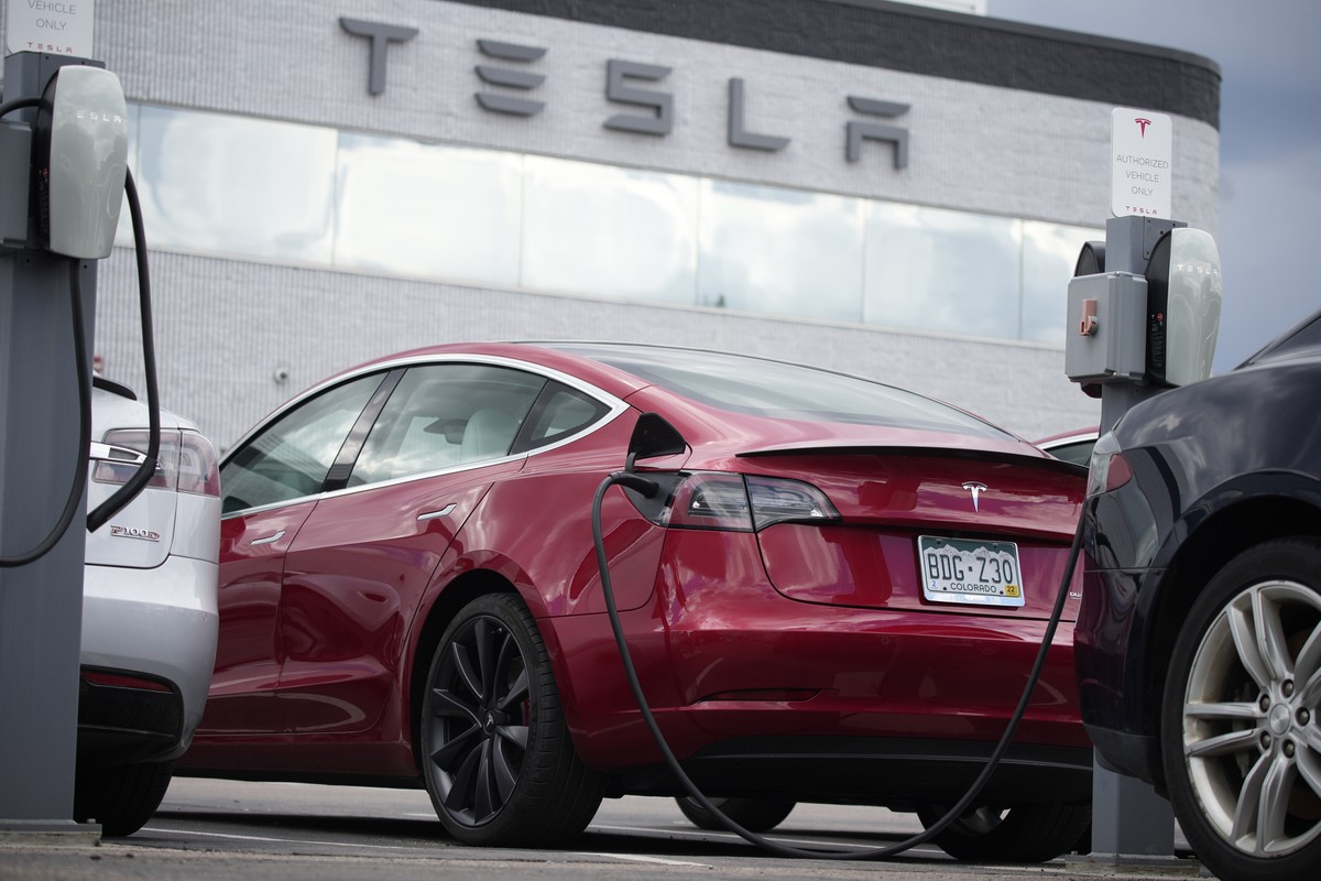 FILE - A 2021 Model 3 sedan is connected to a charger at a Tesla dealership on June 27, 2021, in Littleton, Colo. The National Highway Traffic Safety Administration said Thursday, June 9, 2022, that i ...