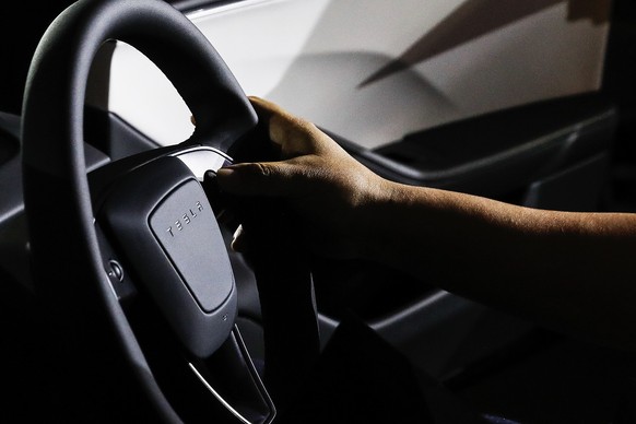 epa10926840 A journalist holds Tesla&#039;s new Model 3 electric car steering during official launch event in Damansara, Malaysia, 19 October 2023. The new model comes in rear-wheel drive and long-ran ...