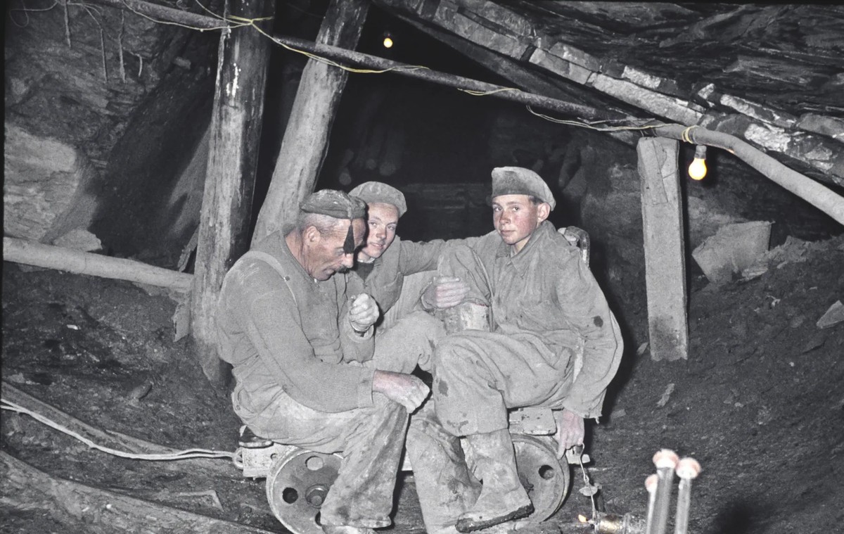 Der Arbeiter Alois Jeremias und zwei seiner Söhne sitzen auf einem Rollwagen in einem Schieferstollen, um 1960.
https://kulturgutstiftung.ch/themen-2/industrie/schiefer/