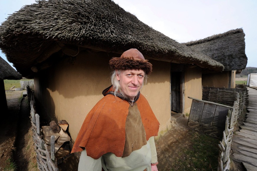 epa02663910 Employee of the Haithabu Museum, Reinhard Erichsen, is pictured in traditional Viking clothes at the open-air site of a recreated Viking town at the Haithabu Viking Museum near Schleswig,  ...