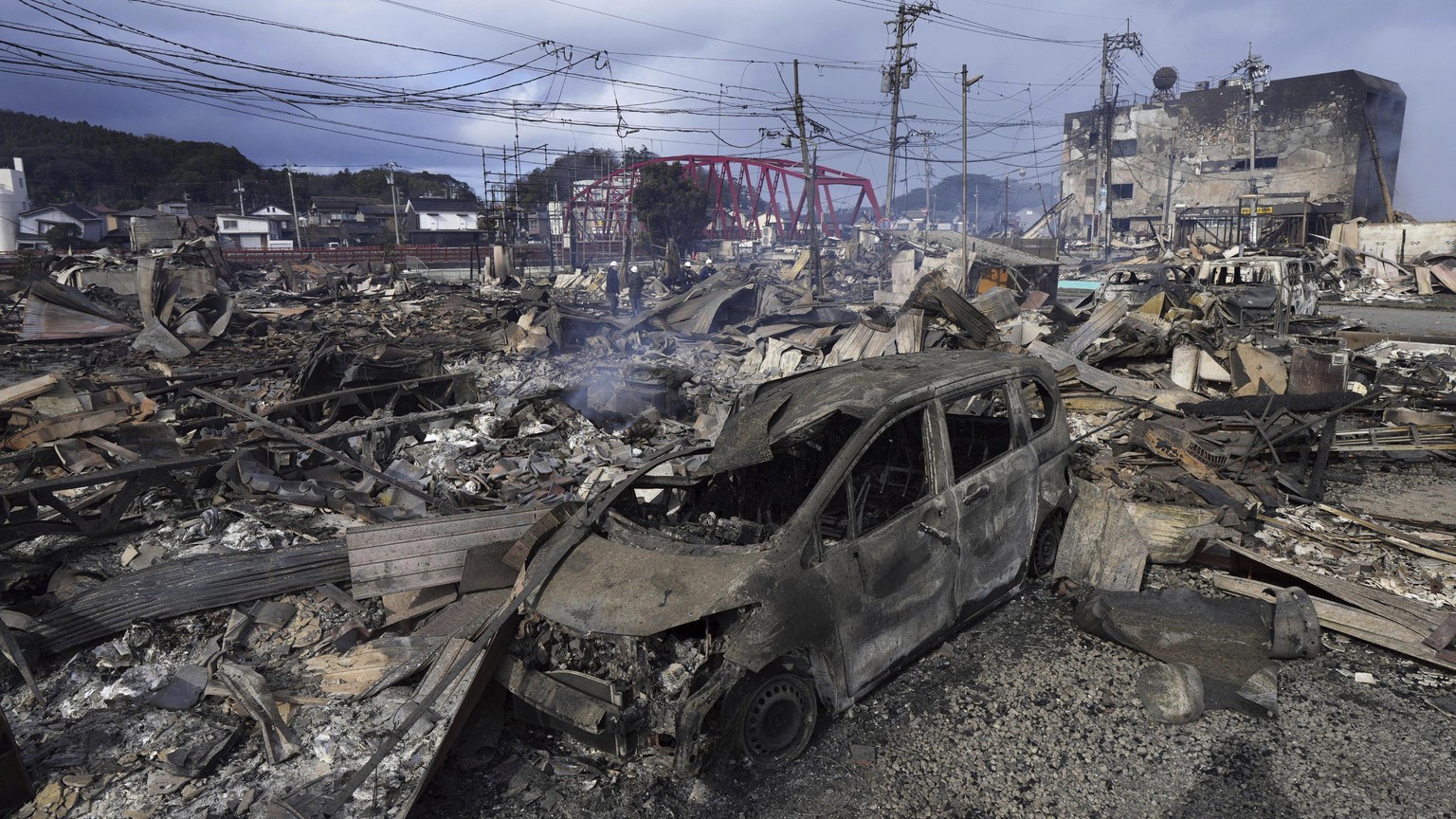 A burnt car and debris are seen at a marketplace after a fire following strong earthquake in Wajima, Ishikawa prefecture, Japan Tuesday, Jan. 2, 2024. A series of powerful earthquakes hit western Japa ...