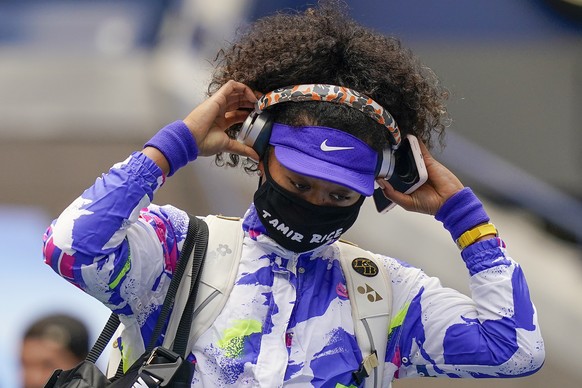 FILE - In this Sept. 12, 2020, file photo, Naomi Osaka, of Japan, pulls off her headphones as she walks on the court before playing against Victoria Azarenka, of Belarus, in the women&#039;s singles f ...