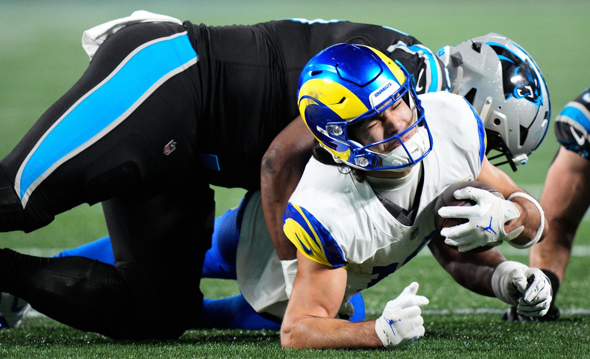 Los Angeles Rams wide receiver Puka Nacua, bottom, is tackled by Carolina Panthers defensive end Derrick Brown during the second half of an NFL wild-card playoff football game, Saturday, Jan. 10, 2026 ...