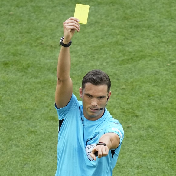 Referee Sandro Schaerer shows a yellow card to someone on the Slovenia bench during a Group C match between Slovenia and Denmark at the Euro 2024 soccer tournament in Stuttgart, Germany, Sunday, June  ...