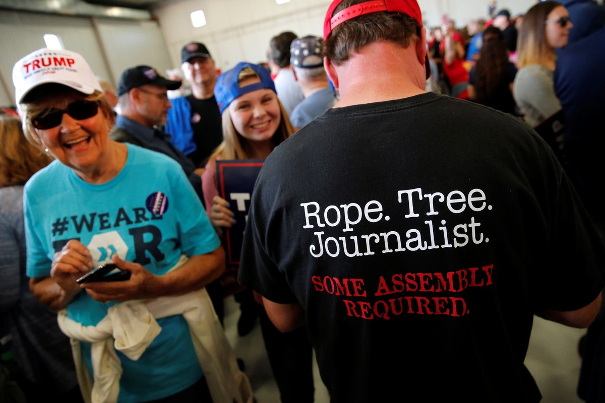 A man wears a shirt reading "Rope. Tree. Journalist." as supporters gather to rally with Republican presidential nominee Donald Trump in a cargo hangar at Minneapolis Saint Paul Internationa ...