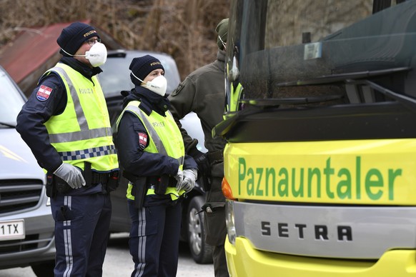 Police at a roadblock stop a bus from driving out of the Paznauntal, near Landeck, Austrian province of Tyrol, Saturday, March 14, 2020. Due to the Covid-19 virus, the towns of St. Anton am Arlberg an ...