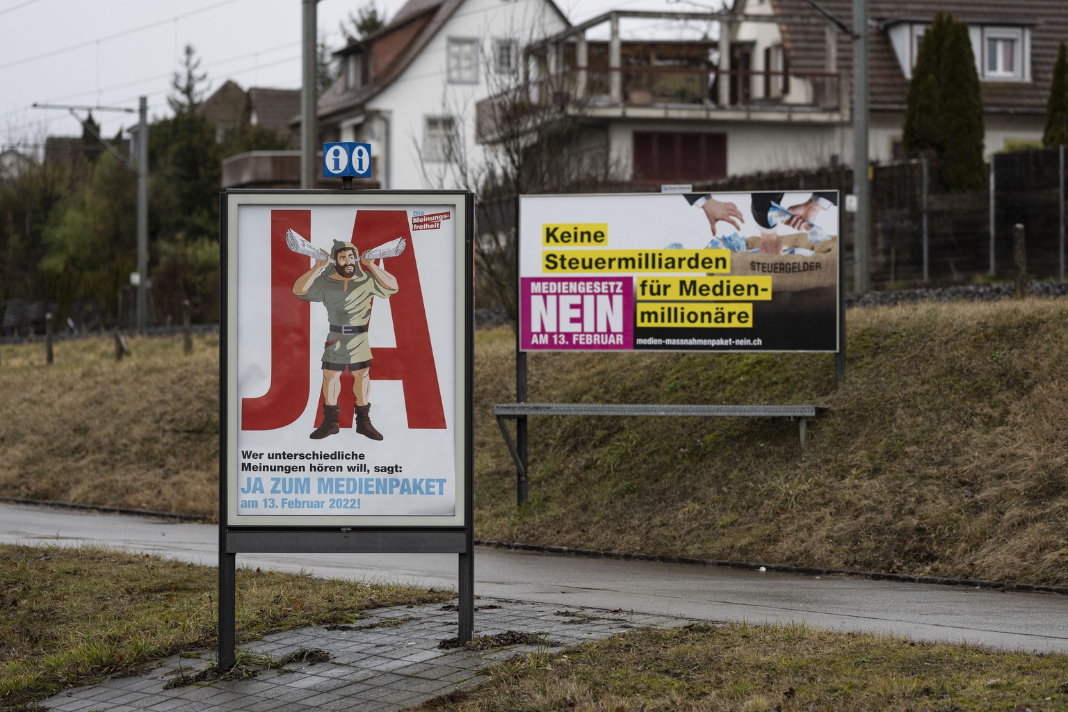 Ein Plakat mit der Aufschrift &quot;Wer Nachrichten aus seiner Region will, sagt: Ja zum Medienpaket&quot;, fotografiert am Montag, 31. Januar 2022 Vor dem Plakat der Gegner am Strassenrand in Wallise ...