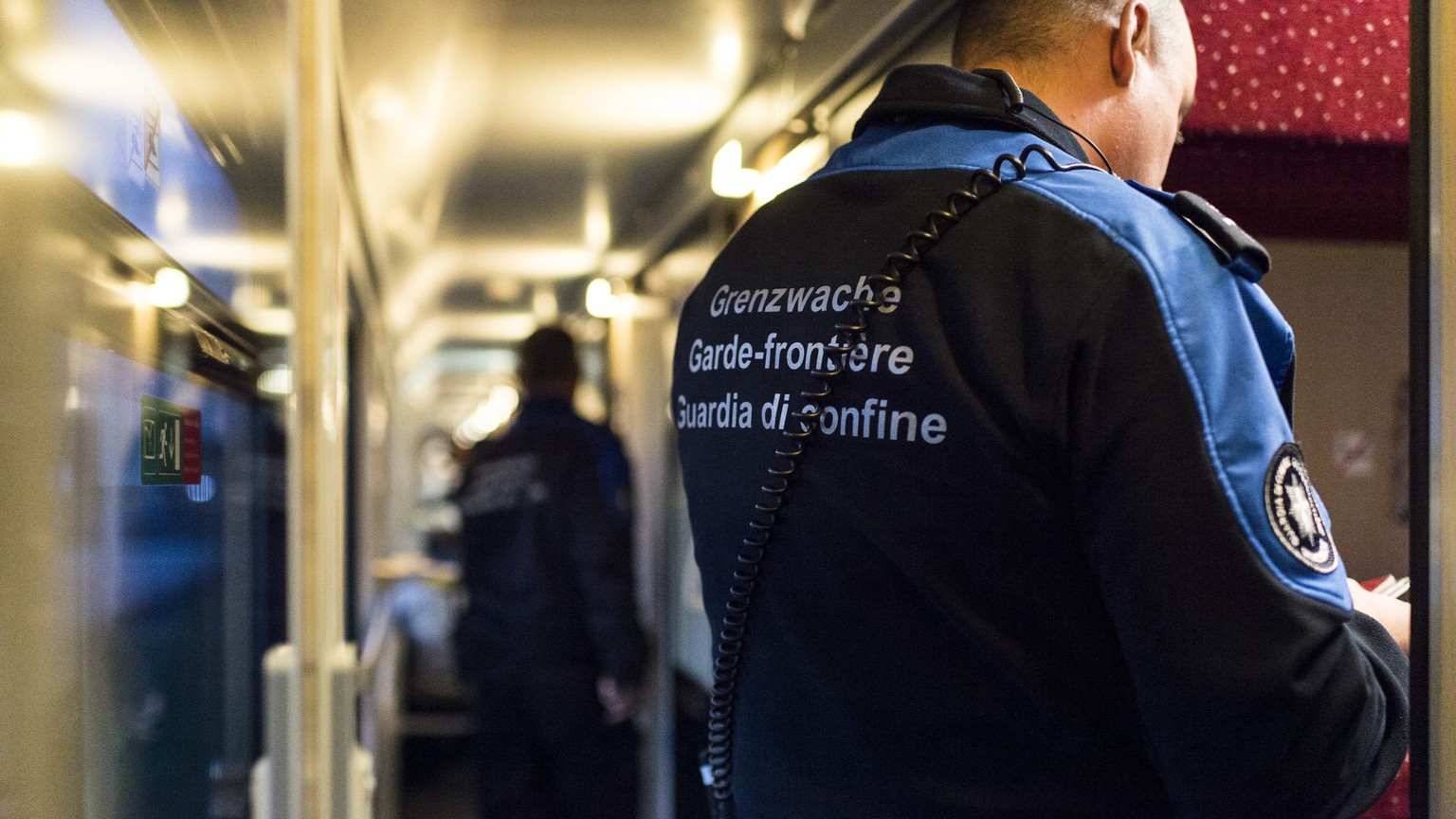 Grenzwaechter kontrollieren einen Zug, am Dienstag, 10. November 2015, am Bahnhof in Buchs. Im September kamen erstmals mehr Fluechtlinge an der Ostgrenze als im Tessin an. (KEYSTONE/Gian Ehrenzeller)