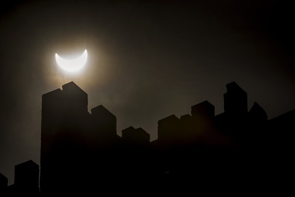 The solar eclipse is seen through the clouds above the castle "Tourbillon" in Sion, Switzerland, Friday, March, 20, 2015. A Partial Solar Eclipse is seen today in Europe, northern and easter ...