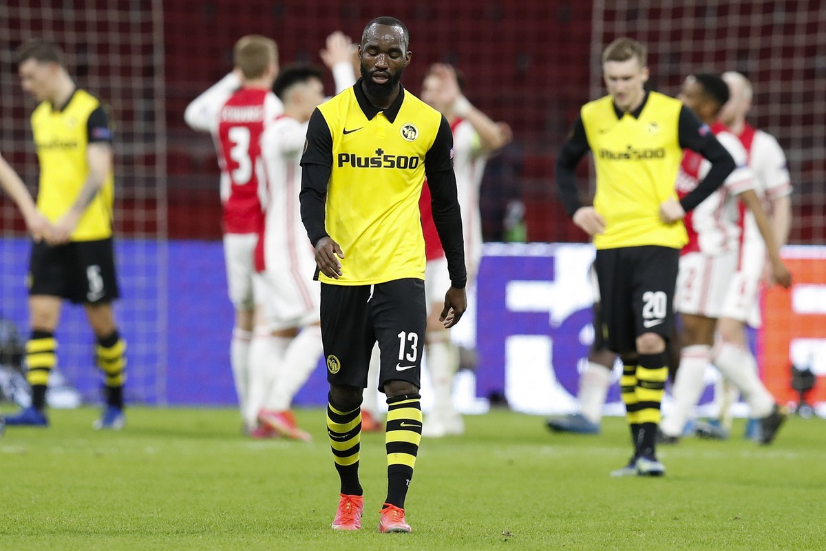 Young Boys' Nicolas Moumi Ngamaleu reacts while Ajax players celebrate after scoring the 3-0 during the round of 16, 1st leg UEFA Europa League match between Netherland's Ajax Amsterdam and  ...