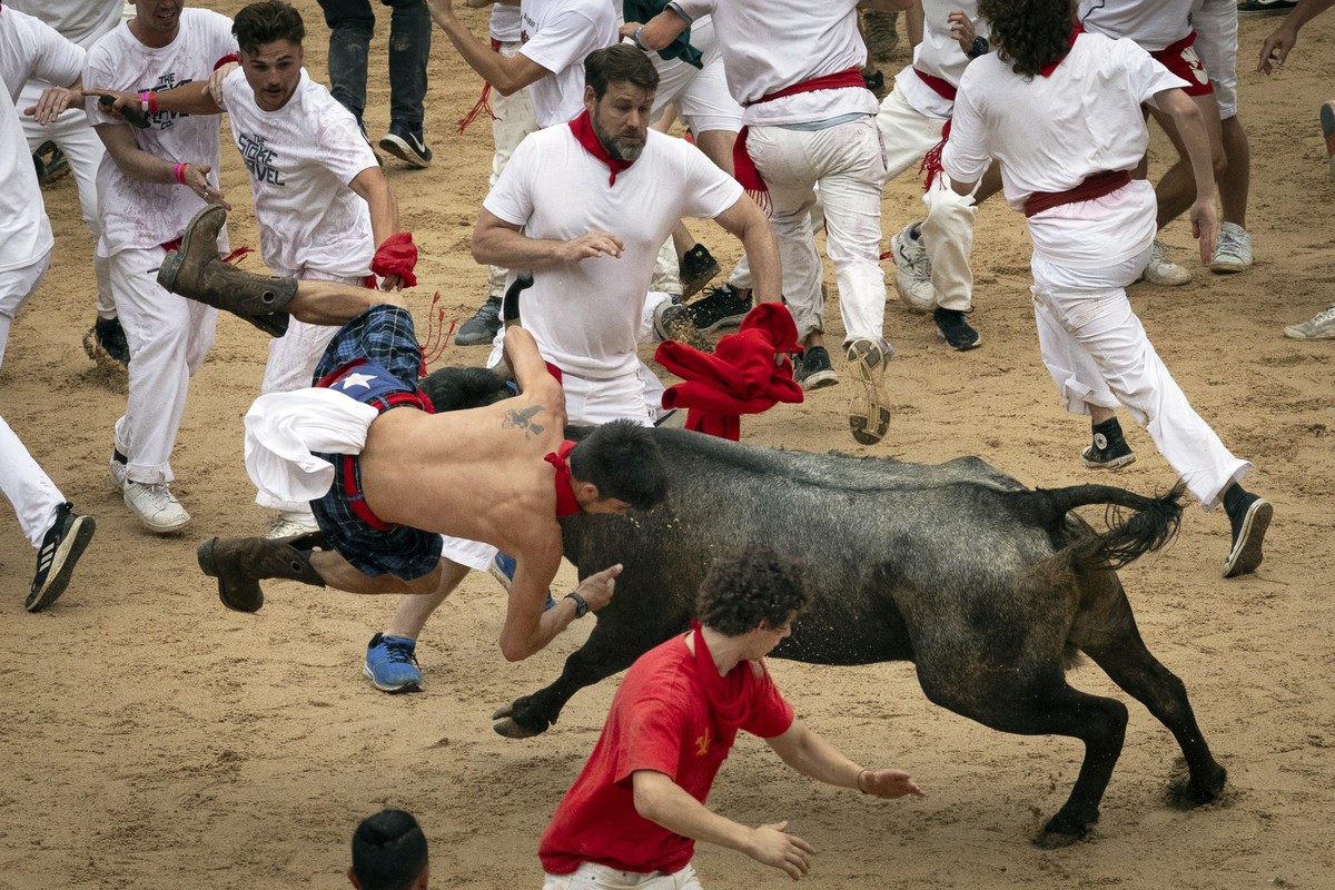 epa10731433 A mozo or runner is turned upside down by a young calf at the bullring at the end of the first bull run of Sanfermines 2023 in Pamplona, northern Spain, 07 July 2023. Pamplona's Runni ...