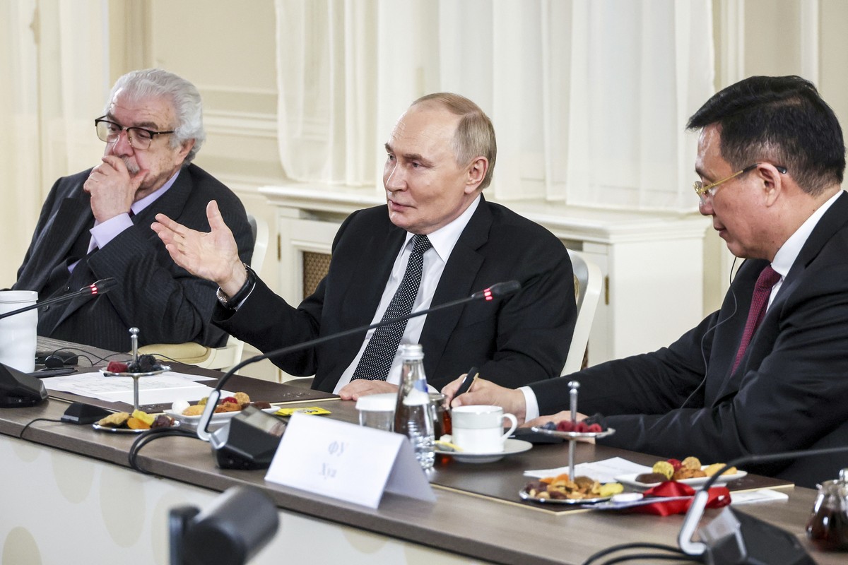CORRECTS PHOTOGRAPHER'S NAME TASS news agency First Deputy Director General Mikhail Gusman, left, and Xinhua News Agency President Fu Hua, right, attend a meeting of Russian President Vladimir Pu ...
