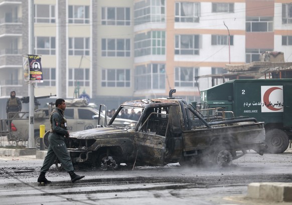 Afghan security personnel inspect the site of a bombing attack in Kabul, Afghanistan, Sunday, Dec. 20, 2020. The strong car bomb explosion rocked the capital Kabul city on Sunday morning, killing mult ...