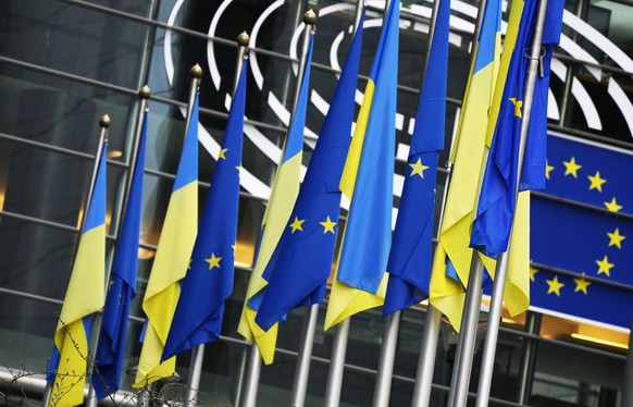 Ukraine and European Union flags hang together on the exterior of the building prior to an extraordinary plenary session on Ukraine at the European Parliament in Brussels, Tuesday, March 1, 2022. The  ...