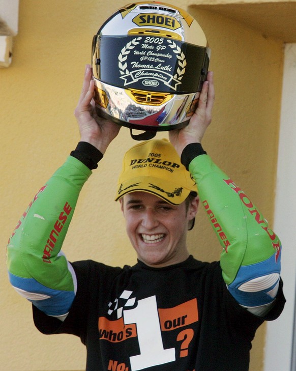 ARCHIV - ZUR RUECKTRITTSANKUENDIGUNG VON TOM LUETHI STELLEN WIR IHNEN FOLGENDES BILDMATERIAL ZUR VERFUEGUNG - Swiss rider Thomas Luethi of Honda hoists his helmet on the podium after becoming the new  ...