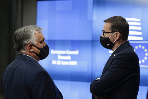 Poland&#039;s Prime Minister Mateusz Morawiecki, right, talks to Hungary&#039;s Prime Minister Viktor Orban before they leave at the end of the first day of an EU summit at the European Council buildi ...