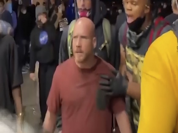 This frame grab from video shot by Julio Rosas on Aug. 25, 2020, in Kenosha, Wis., shows Joseph Rosenbaum, in the red shirt, front center, and Anthony Huber, in the blue hat behind Rosenbaum, confront ...