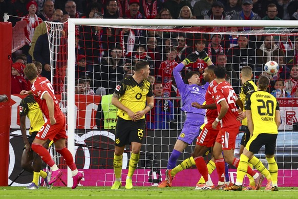 epa12462586 Harry Kane of Munich (2L) scores against goalkeeper Gregor Kobel of Dortmund (C) the 1-0 during the German Bundesliga soccer match between Bayern Munich and Borussia Dortmund in Munich, Ge ...