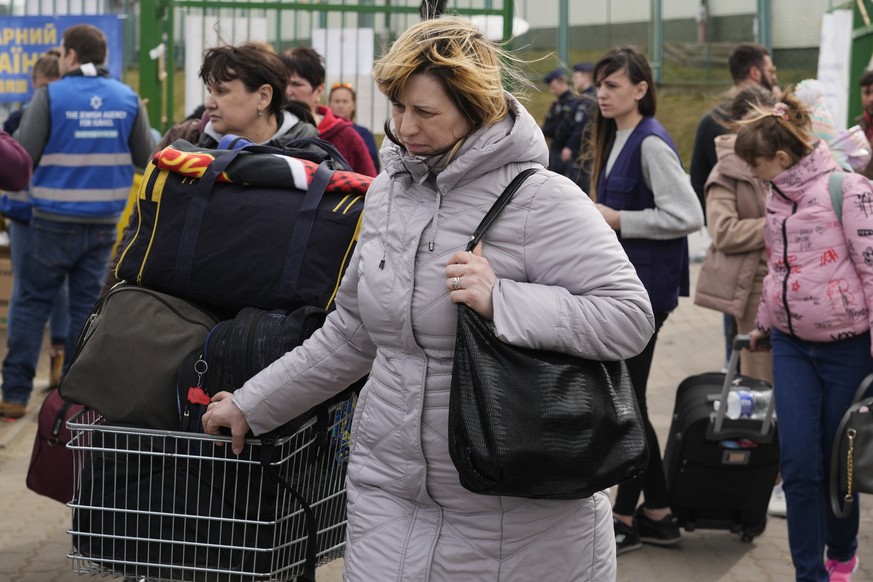 Refugees walk after fleeing the war from neighbouring Ukraine at the border crossing in Medyka, southeastern Poland, Thursday, April 7, 2022. (AP Photo/Sergei Grits)