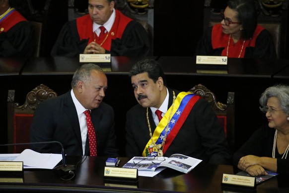 Venezuelan President Nicolas Maduro, center, listens to Constitutional Assembly President Diosdado Cabello at the Supreme Court during an annual ceremony that marks the start of the judicial year in C ...