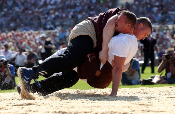 Swiss Alpine wrestlers Christian Stucki (top) and Henryc Thoenen fight during the forth round of the Federal Alpine Wrestling Festival (Eidgenoessisches Schwing- und Aelplerfest) in Estavayer-le-Lac,  ...