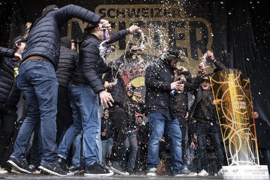 Berns Beat Gerber bekommt eine Bierdusche von seinen Teamkollegen, bei der Meisterfeier des SC Bern, am Samstag, 27. April 2019, auf dem Bundesplatz in Bern. (KEYSTONE/Anthony Anex)