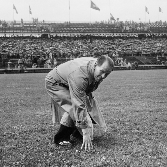 Ahead of the final match of the football world cup at the Wankdorf Stadium in Berne, Switzerland, on July 4, 1954, national coach Sepp Herberger checks the grass in the stadium after heavy rains. The  ...