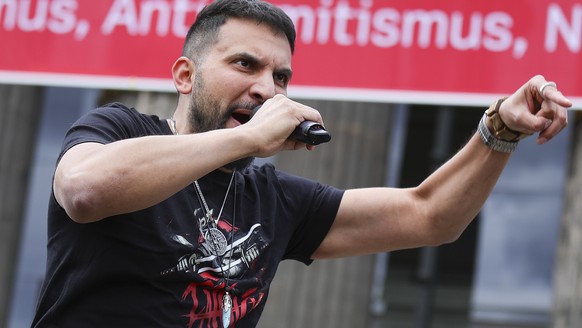 epa08540647 German vegan chef Attila Hildmann, speaks to his followers during an anti-restrictions protest at the Lustgarten park in Berlin, Germany, 11 July 2020. Hildmann supporters demonstrate main ...