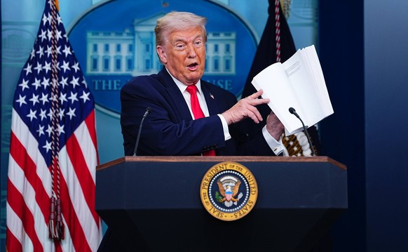 Trump Joins White House Briefing United States President Donald J Trump leafs through a book of his administrations accomplishments as he joins the White House briefing in the James S Brady Press Brie ...
