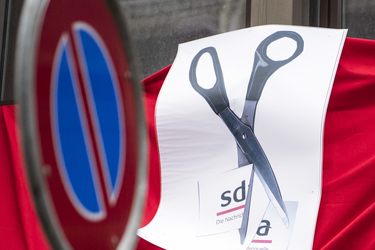 Eine Schere zerschneidet auf einem Transparent das SDA-Logo am Dienstag, 23. Januar 2018, in Bern. Journalistinnen und Journalisten der Schweizerischen Depeschenagentur SDA sowie Gewerkschaftsvertrete ...