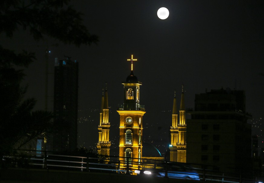 epa06365577 The full moon is seen on the sky over Al-Ameen Mosque and St. Gregory church, Beirut, Lebanon, 03 December 2017. According to the National Aeronautics and Space Administration (NASA) a ser ...