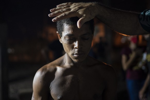 A member of the God&#039;s Love Evangelical Church and Rehab Center prays with a drug user in an area known as &quot;cracolandia&quot; or crackland, amid the COVID-19 pandemic in Rio de Janeiro, Brazi ...
