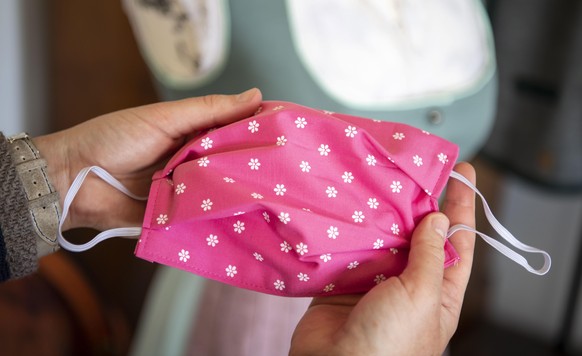 epa08417039 Tailor Babs Wuertz shows a face mask made of traditional costume fabric in Essenbach near Landshut, Bavaria, Germany, 12 May 2020. Wuertz makes tailor-made costumes, since the outbreak of  ...