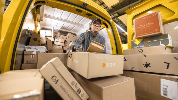 Der Paketbote der Schweizerischen Post Carlos Hugo Vega sortiert Pakete beim Beladen der Lieferwagen fuer die Zustellung, in der Distributionsbasis Oerlikon, aufgenommen am Dienstag, 5. Dezember 2023  ...